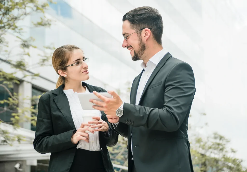 happy businessman businesswoman standing outside office looking each other